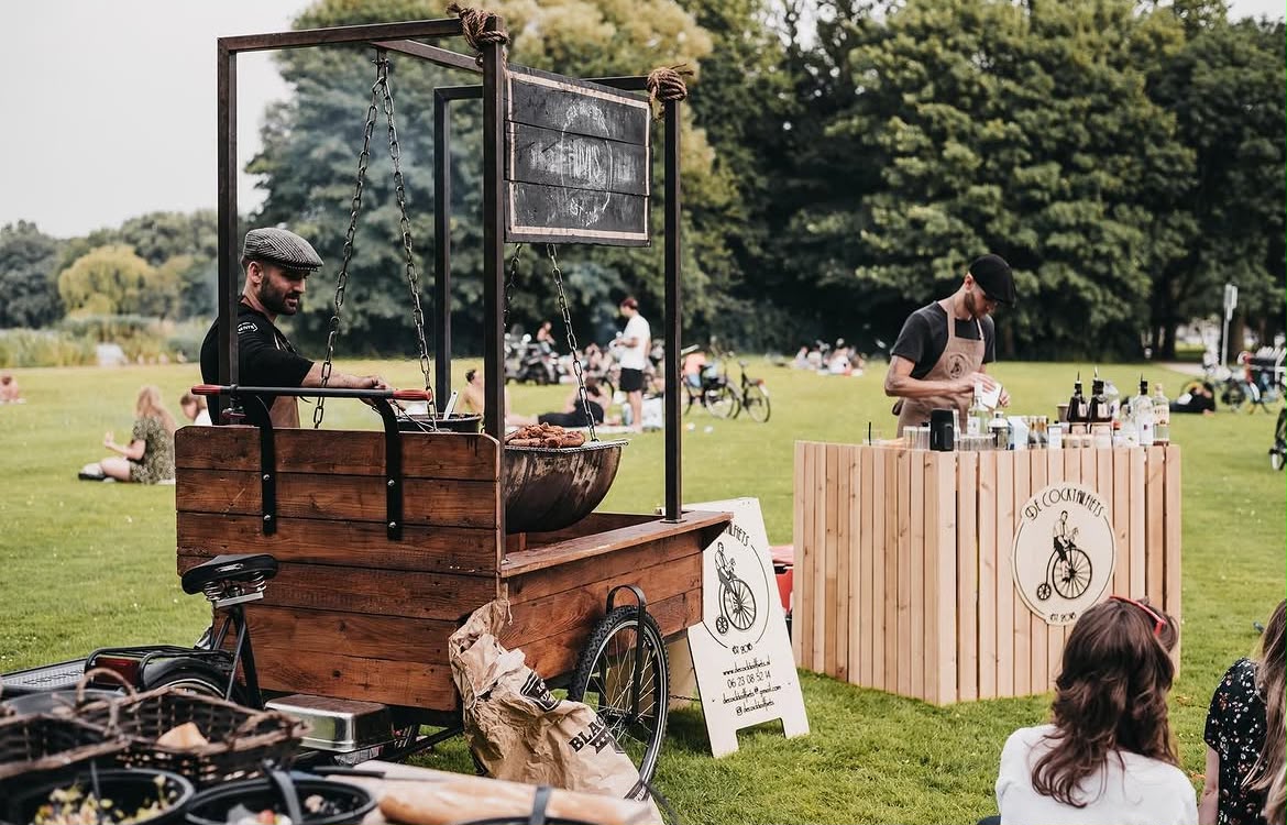 De houten BBQ-kar met hangende vuurschaal in het park