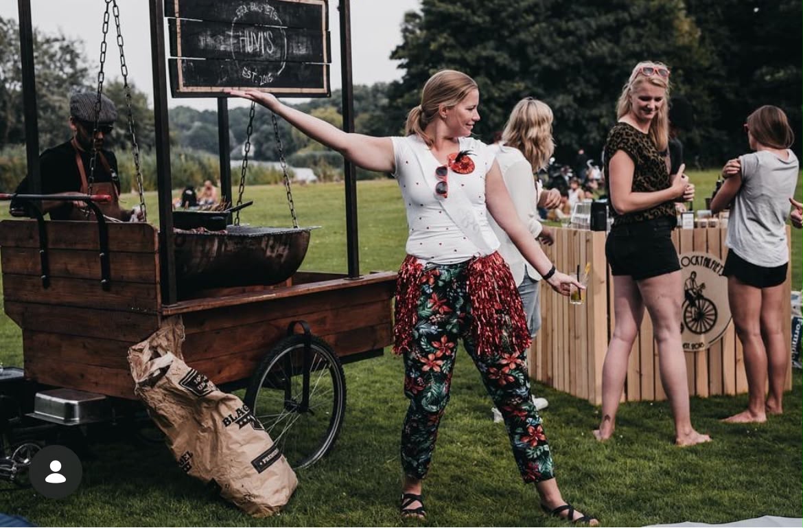 Gasten bij de BBQ-kar tijdens een feest in het park
