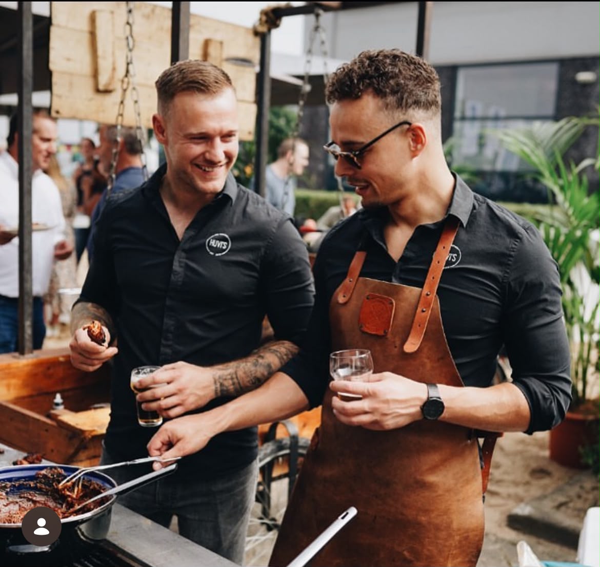 Twee gasten met een borrel bij de grill