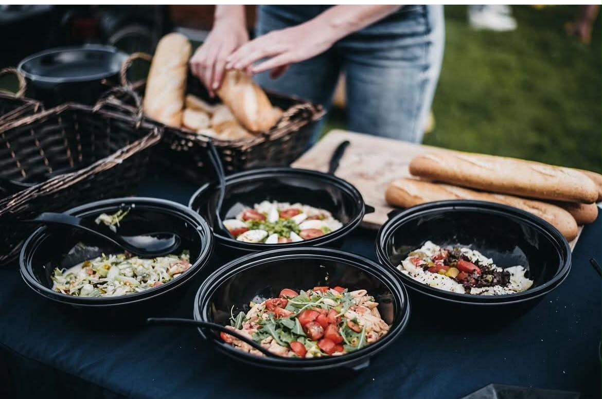 Vier verse salades en manden met stokbrood op het buffet